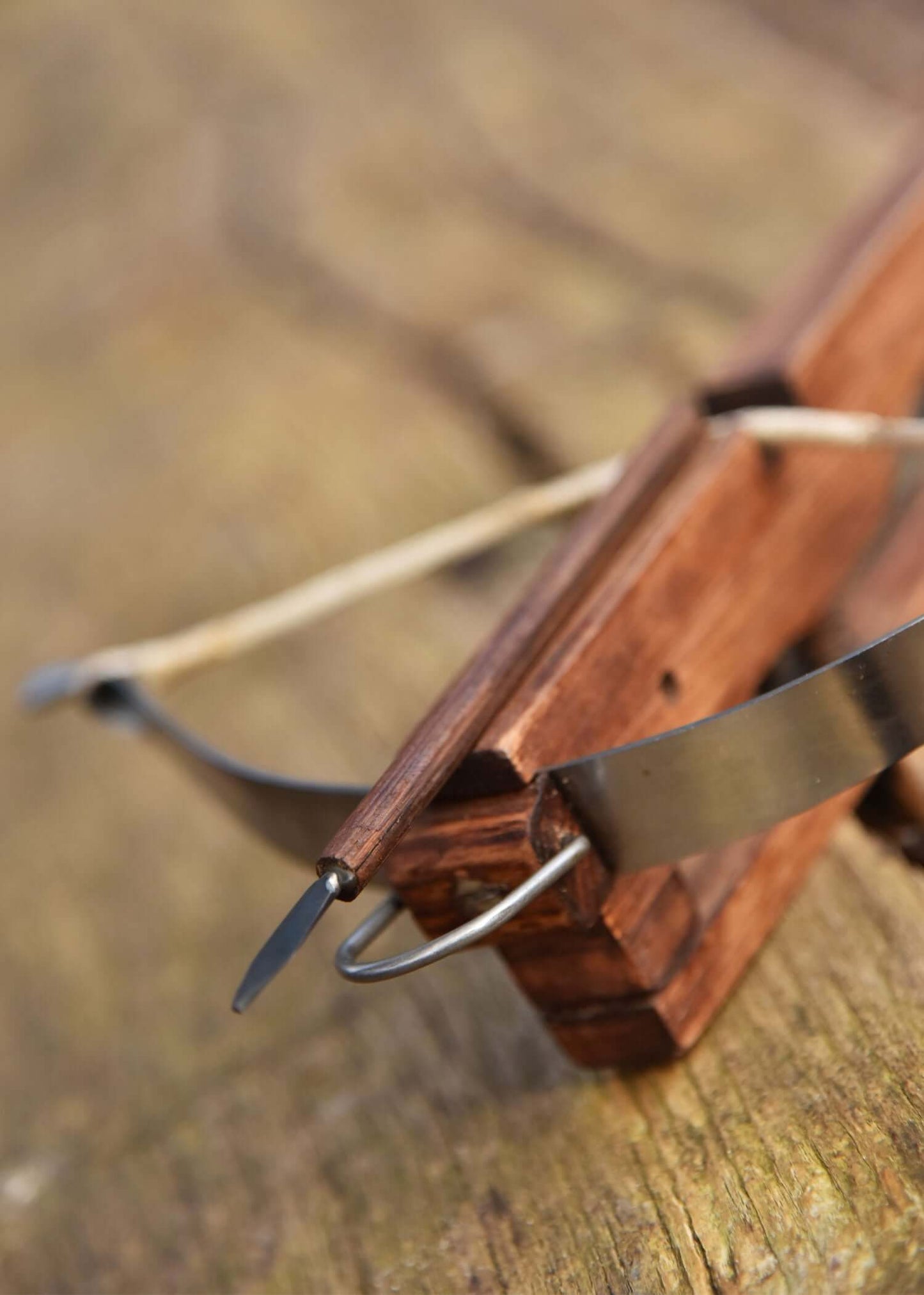 Detailaufnahme einer funktionalen Miniatur-Armburst aus Holz mit Metallkomponenten.