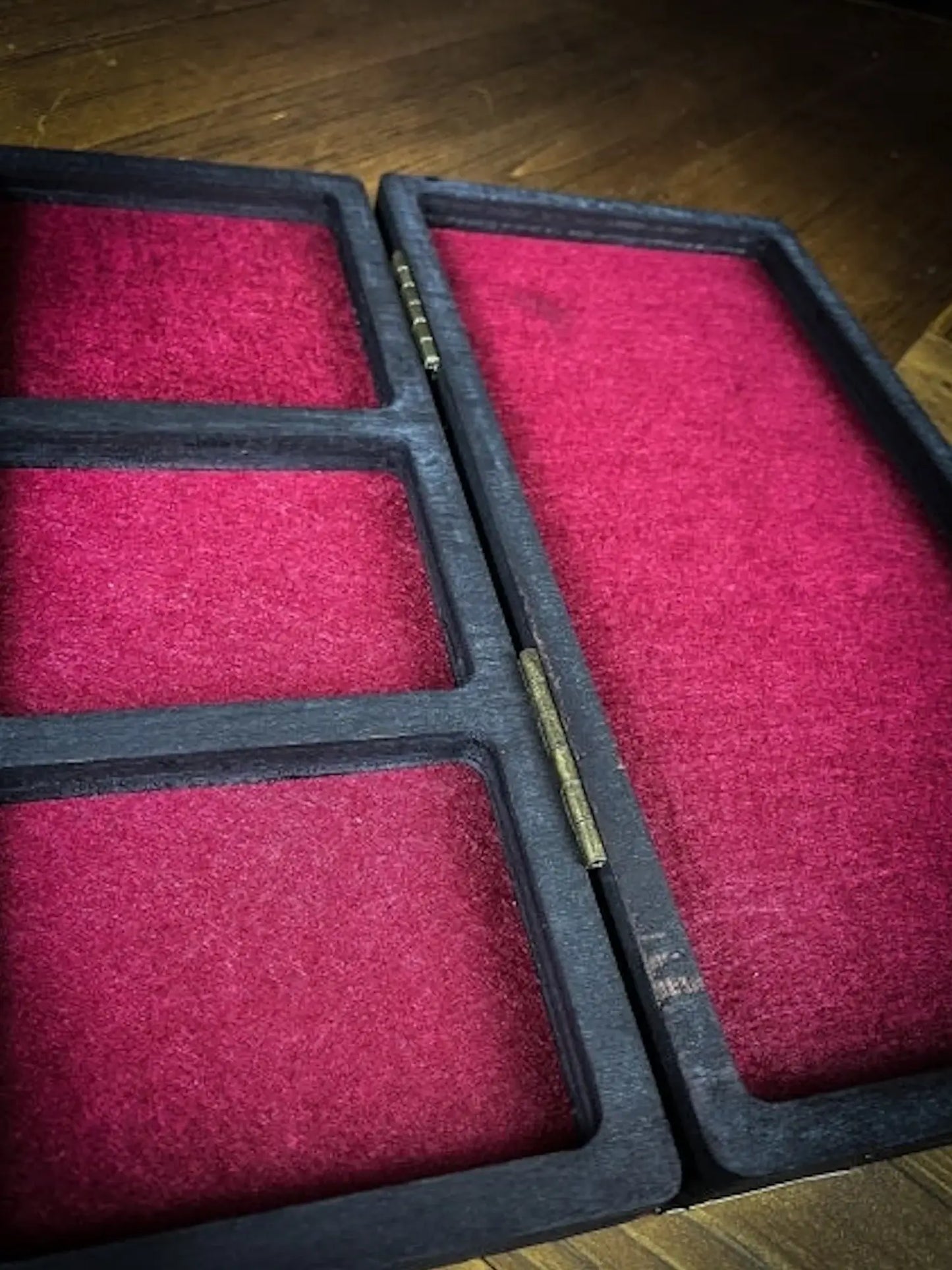 Interior of a Holz Würfelbox with red felt lining, designed for organized die storage in tabletop games.